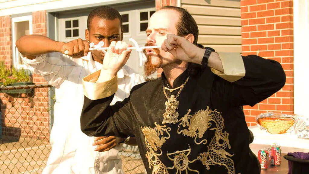 Magician performing a trick with a helper at a backyard party
