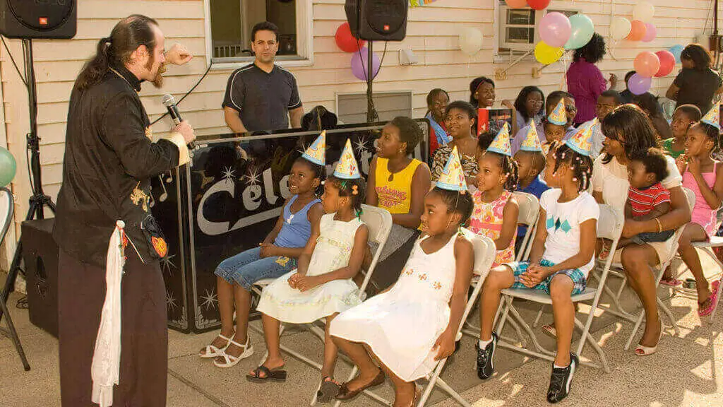 Kids birthday party entertainment ideas: children watching a magician perform at a birthday party