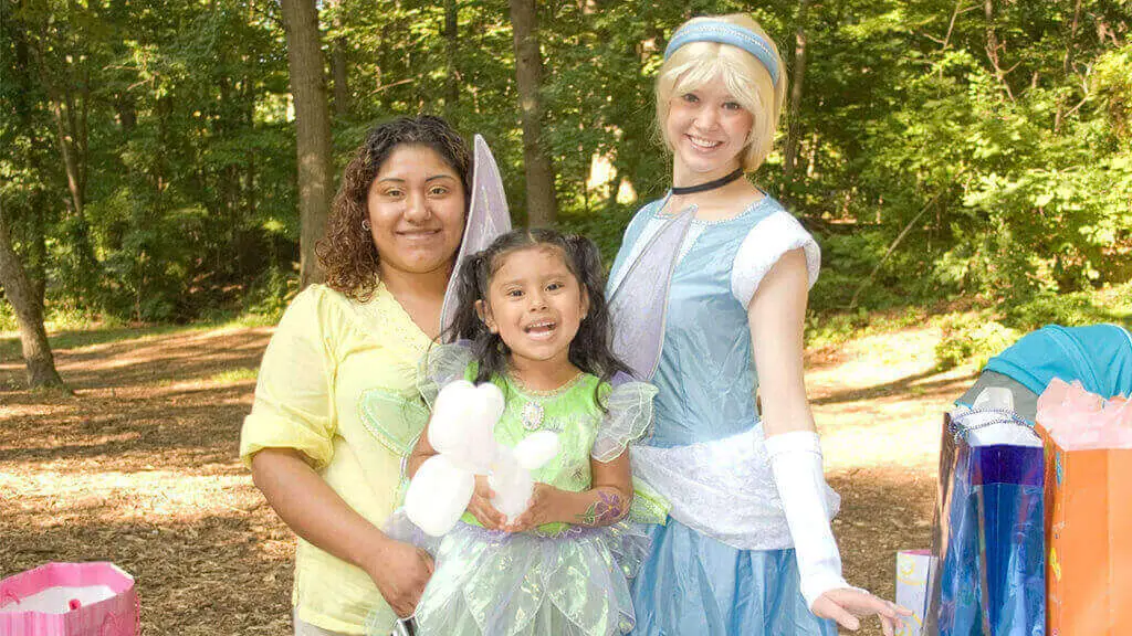Costume princess character visiting a girl and her mom at a kids birthday party