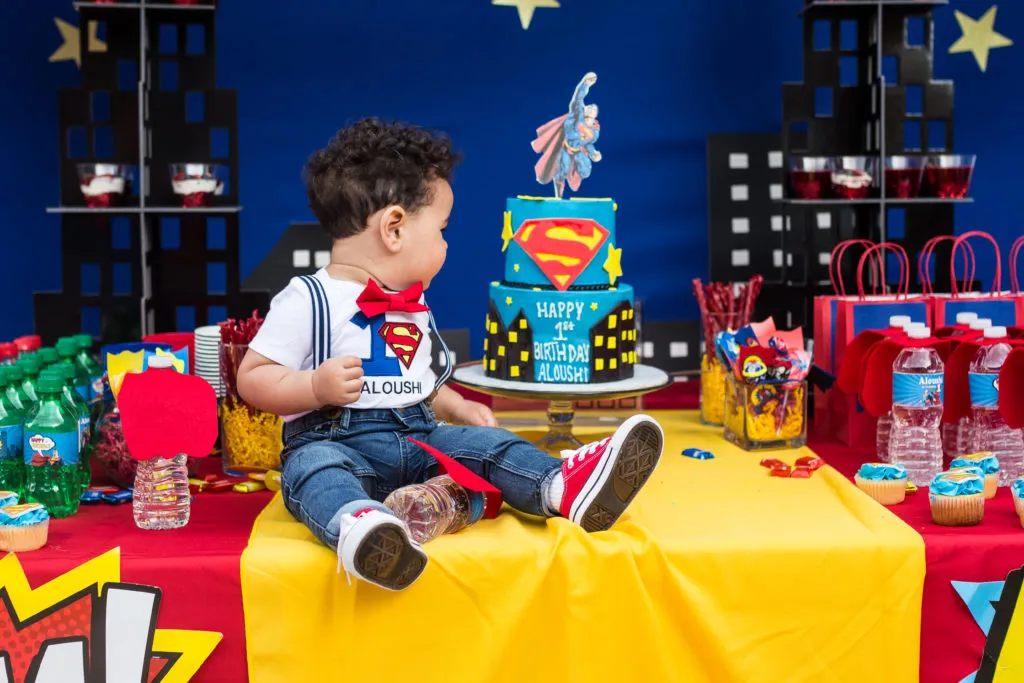 Find Friendly Kids Birthday Party Rentals Near Me 2 birthday party supplies, A superhero-themed birthday setup with colorful decorations, plates, and themed party rentals.