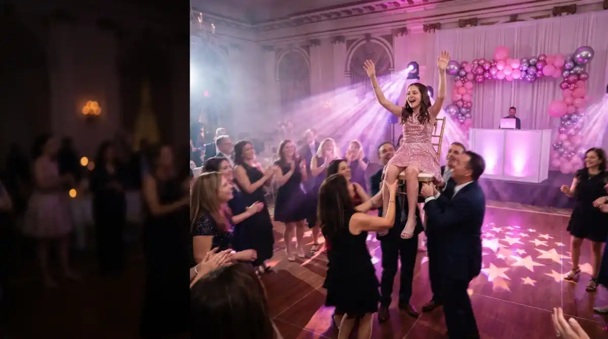 Bat mitzvah girl lifted on a chair during the hora with pink uplighting, a gobo pattern on the dance floor and pink and silver balloon decor