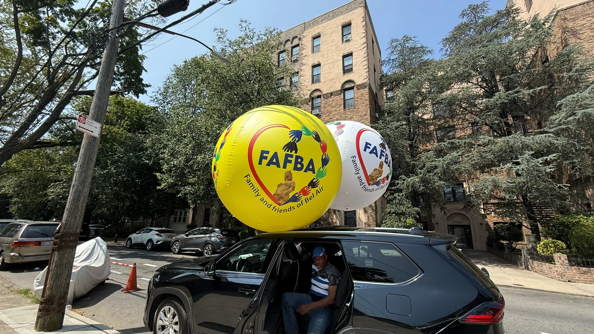 Two large printed advertising balloons filled with helium and secured for transport to the customer's event