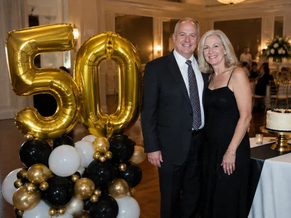 Giant gold number 50 foil balloons on a balloon garland base at a 50th birthday