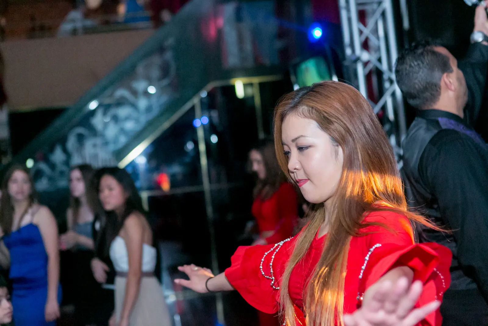 Party dancer in a red costume leading the guests in a group dance