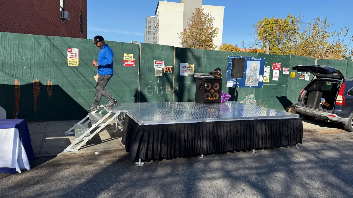 Portable stage with aluminum steps and black skirting set up on a street for a community event in Far Rockaway NY