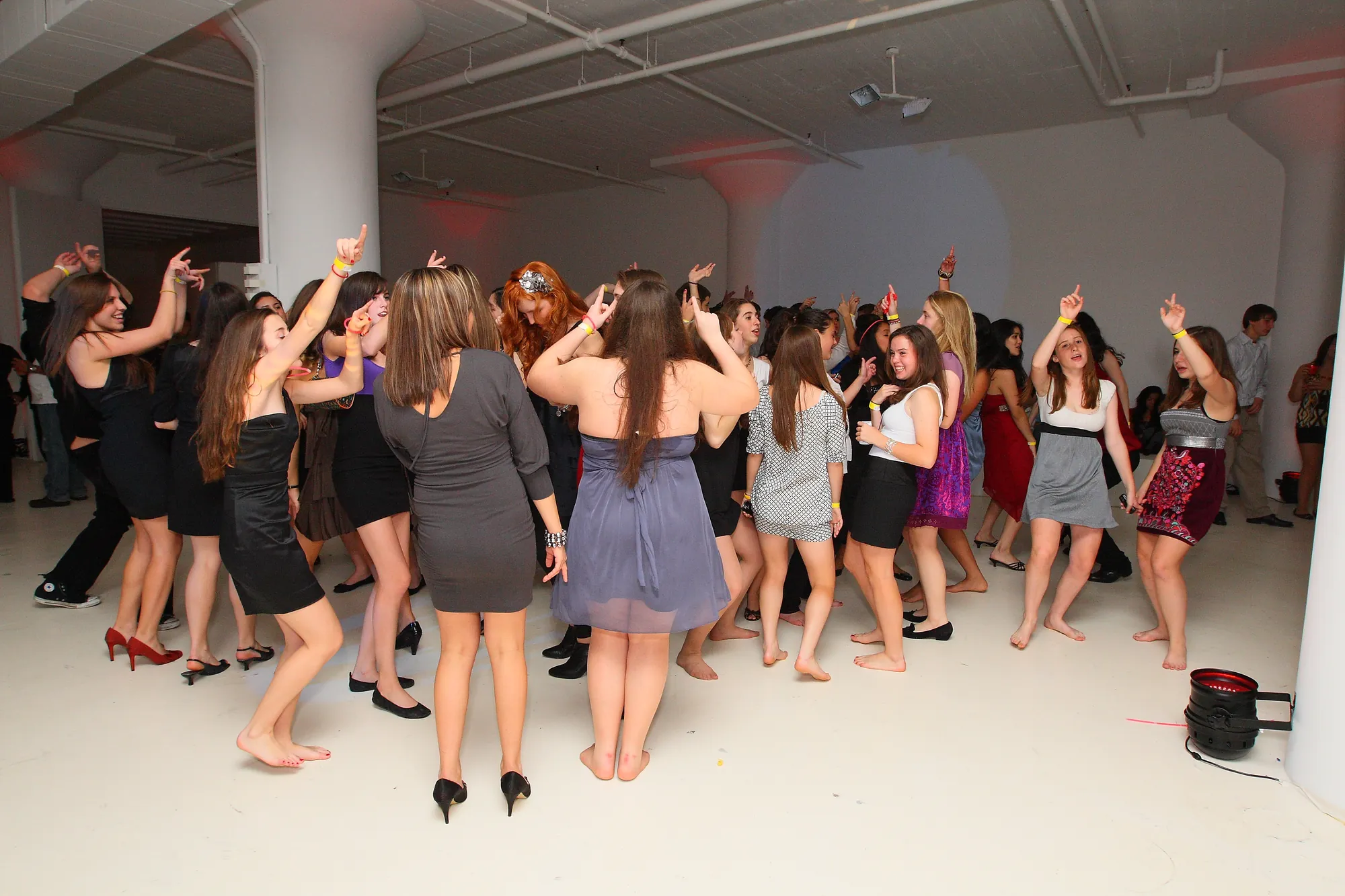 Teenage guests dancing together on a full dance floor at a Sweet 16 party