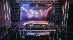 DJ booth with turntables, speakers on stands and truss lighting set up for a party